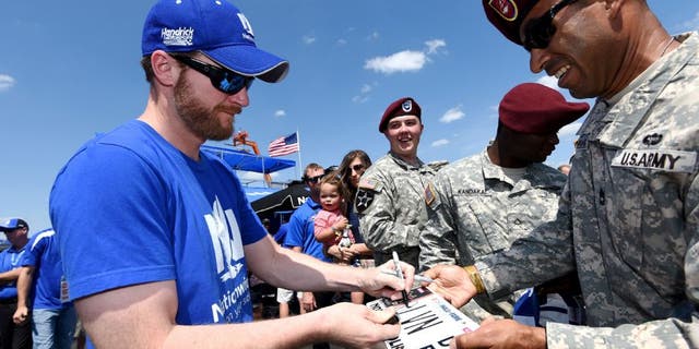CHARLOTTE, NC - MAY 24: Dale Earnhardt Jr., driver of the #88 Nationwide Chevrolet, signs autographs for U.S. Army members prior to the NASCAR Sprint Cup Series Coca-Cola 600 at Charlotte Motor Speedway on May 24, 2015 in Charlotte, North Carolina. (Photo by Rainier Ehrhardt/Getty Images)
