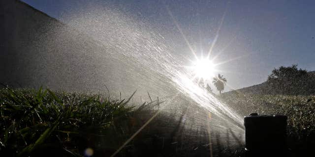 FILE - In this June 23, 2015, file photo, a lawn is irrigated in Sacramento, Calif.
