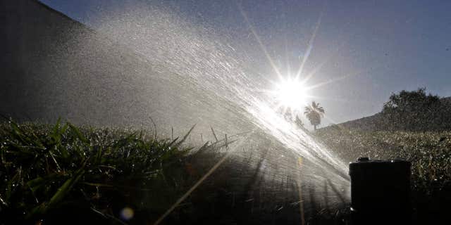 FILE - In this June 23, 2015, file photo, a lawn is irrigated in Sacramento, Calif.
