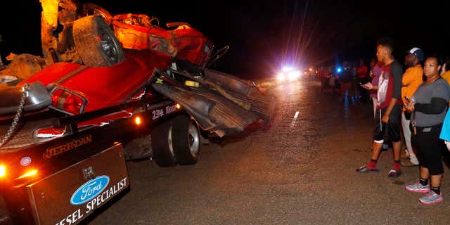 May 18, 2016: Friends and relatives walk past the remains of a pickup truck that collided with Amtrak's "City of New Orleans" passenger train in Flora, Miss..