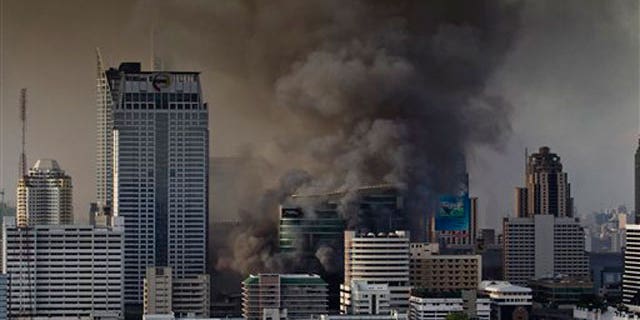 May 19: Smoke rises from burning fires in downtown Bangkok, Thailand, following the surrender of anti-government leaders to the police.