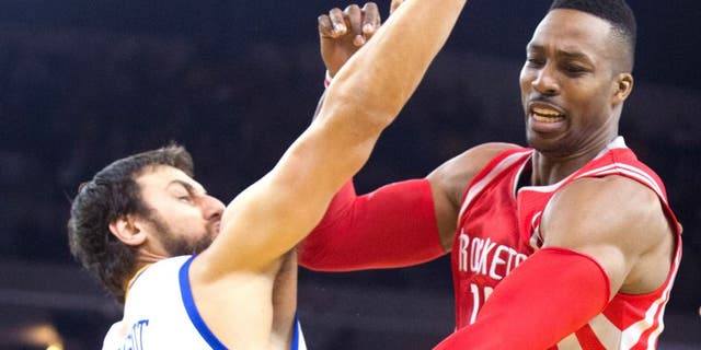Jan 21, 2015; Oakland, CA, USA; Houston Rockets center Dwight Howard (12) controls the ball against Golden State Warriors center Andrew Bogut (12) during the first quarter at Oracle Arena. Mandatory Credit: Kelley L Cox-USA TODAY Sports