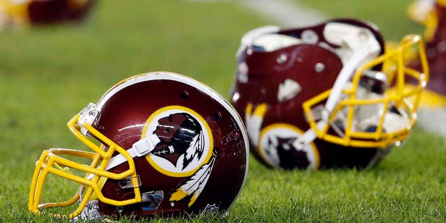 FILE - In this Dec. 26, 2015, file photo, a Washington Redskins helmet sits on the field as players warm-up before an NFL football game against the Philadelphia Eagles in Philadelphia.