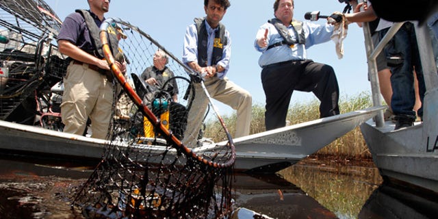 May. 19: Louisiana Gov. Bobby Jindal, center, and Plaquemines Parish President Billy Nungesser, right, tour the oil impacted marsh of Pass a Loutre, La.
