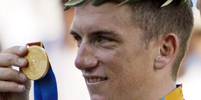 This Aug. 18, 2004, file photo shows Tyler Hamilton of the U.S. holding up his gold medal after the men's road individual time trial of the 2004 Olympic Games in the outskirts of Athens.