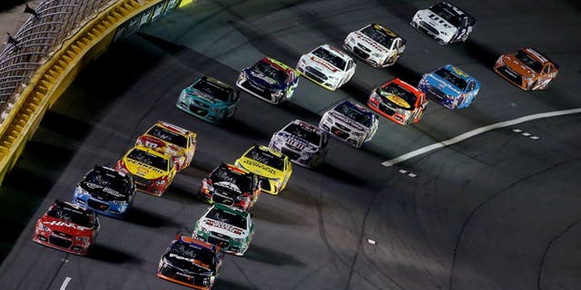 CHARLOTTE, NC - MAY 16: Denny Hamlin, driver of the #11 FedEx Express Toyota, and Kurt Busch, driver of the #41 Haas Automation Chevrolet, lead the field in a restart the NASCAR Sprint Cup Series Sprint All-Star Race at Charlotte Motor Speedway on May 16, 2015 in Charlotte, North Carolina. (Photo by Brian Lawdermilk/Getty Images)