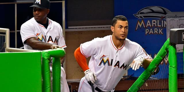 Apr 18, 2016; Miami, FL, USA; Miami Marlins hitting coach Barry Bonds (left) talks with Marlins right fielder Giancarlo Stanton (right) at the steps of the dugout during the second inning of a game against the Washington Nationals at Marlins Park. Mandatory Credit: Steve Mitchell-USA TODAY Sports