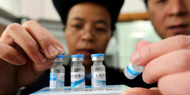 FILE - In this Monday, March 21, 2016 file photo, officials from China's State Food and Drug Administration inspect vaccines stored at the local Center for Disease Control and Prevention office in Rong'an county in southwestern China's Guangxi Zhuang Autonomous Region.