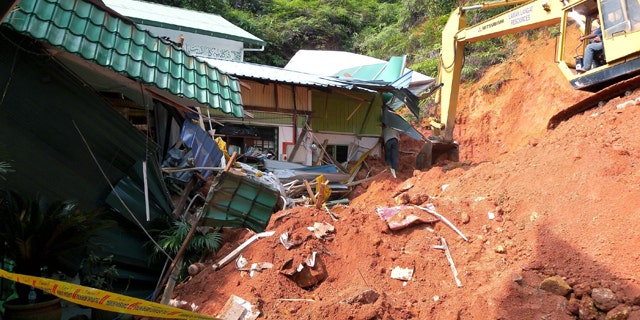 May 21: A rescuer uses a construction machine to search for the bodies believed to be buried by a landslide in Hulu Langat in central Selangor state, outside Kuala Lumpur, Malaysia.