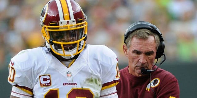 Sep 15, 2013; Green Bay, WI, USA; Washington Redskins quarterback Robert Griffin III (10) and head coach Mike Shanahan walk on the sidelines during the game against the Green Bay Packers in the third quarter at Lambeau Field. Mandatory Credit: Benny Sieu-USA TODAY Sports
