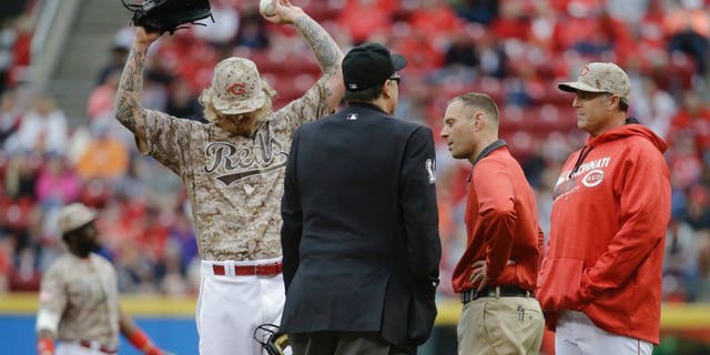 Cincinnati Reds starting pitcher John Lamb, left, reacts alongside manager Bryan Price, right, and umpire Tony Randazzo, center, after being hit by a line drive from Seattle Mariners' Dae-Ho Lee in the fourth inning of a baseball game, Saturday, May 21, 2016, in Cincinnati. (AP Photo/John Minchillo)