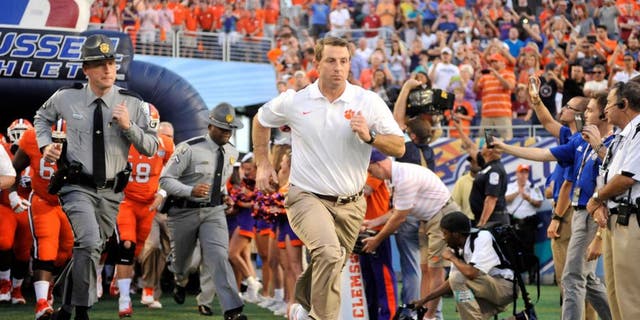 Dec 29, 2014; Orlando, FL, USA; Clemson Tigers head coach Dabo Swinney runs onto the field before the 2014 Russell Athletic Bowl at Florida Citrus Bowl. Mandatory Credit: David Manning-USA TODAY Sports