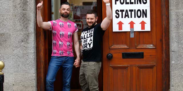 May 22, 2015: Partners Adrian, left and Shane, arrive to cast their vote at a polling station in Drogheda, Ireland.