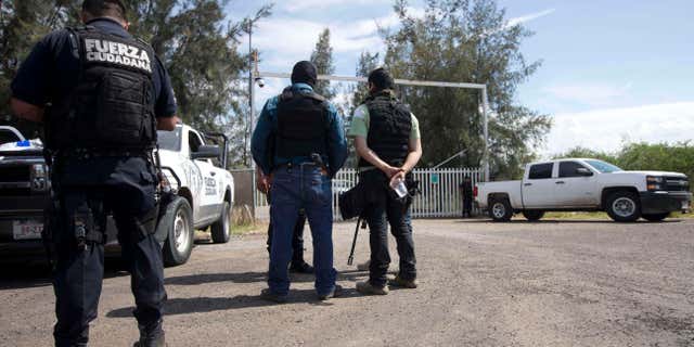 May 22, 2015: Mexican state police stand guard at the entrance of Rancho del Sol, near Vista Hermosa, Mexico.