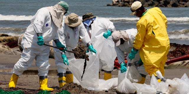 May 24: Workers shovel oil from the Deepwater Horizon spill off Fourchon Beach in Port Fourchon, La.