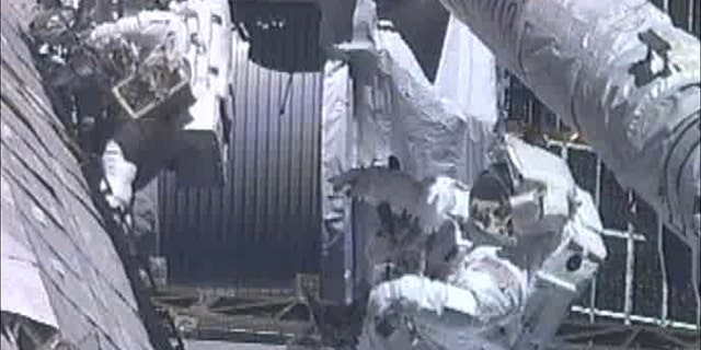 May 27: In this image from NASA television astronauts Greg Chamitoff , foreground, and Mike Fincke work outside the International Space Station repositioning the shuttle’s Orbiter Boom Sensor System during the fourth spacewalk.
