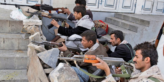 May 24: Tribesmen take positions next to the house of Sheik Sadeq al-Ahmar, the head of the powerful Hashid tribe, during clashes with Yemeni security forces in Sanaa, Yemen.