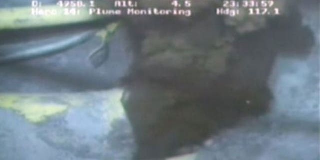 This image from a video released by BP shows oil spewing from a yellowish, broken pipe 5,000 feet below the surface (AP).