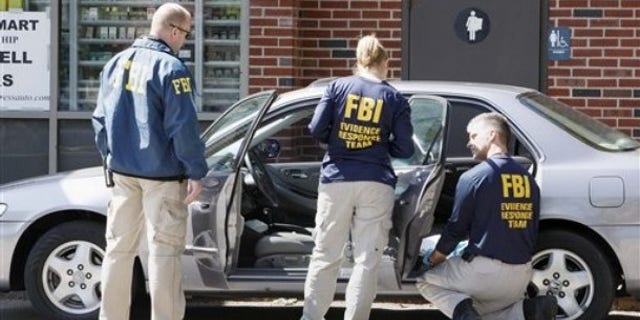 May 13: FBI investigators search a car at a service station in Brookline, Mass., in connection with the failed New York Times Square car bomb (AP).