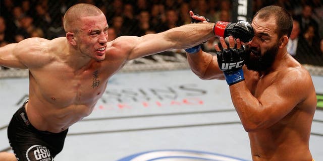 LAS VEGAS, NV - NOVEMBER 16: (L-R) Georges St-Pierre punches Johny Hendricks in their UFC welterweight championship bout during the UFC 167 event inside the MGM Grand Garden Arena on November 16, 2013 in Las Vegas, Nevada. (Photo by Josh Hedges/Zuffa LLC/Zuffa LLC via Getty Images)