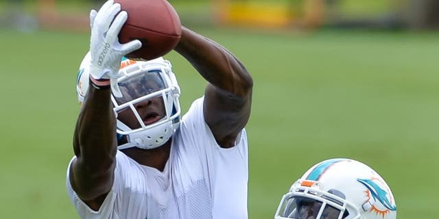 May 26, 2015; Miami, FL, USA; Miami Dolphins wide receiver DeVante Parker (11) makes a catch as Miami Dolphins cornerback Brent Grimes (21) defends during practice drills at Miami Dolphins Training Facility. Mandatory Credit: Steve Mitchell-USA TODAY Sports
