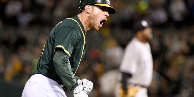 May 28, 2015; Oakland, CA, USA; Oakland Athletics third baseman Brett Lawrie (15, left) celebrates after hitting a two-run home run during the sixth inning against New York Yankees starting pitcher CC Sabathia (52, right) at O.co Coliseum. Mandatory Credit: Kyle Terada-USA TODAY Sports