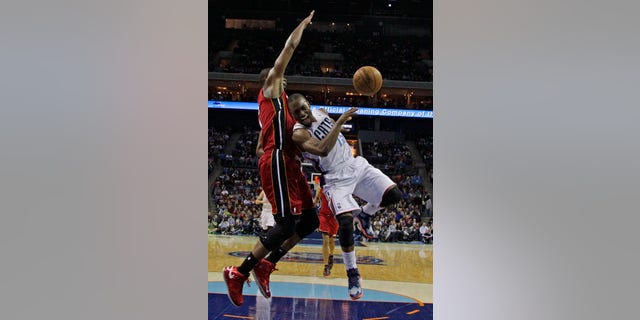 Charlotte Bobcats' Kemba Walker, right, loses the ball as he drives against Miami Heat's Chris Bosh, left, during the second half of an NBA basketball game in Charlotte, N.C., Saturday, Jan. 18, 2014. Walker was injured on the play. The Heat won 104-96 in overtime. (AP Photo/Chuck Burton)