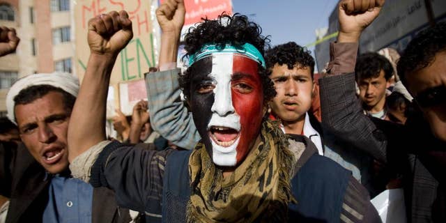 A Houthi Shiite rebel with Yemen's flag painted on his face chants slogans during a rally to show support for leader of rebels, Abdel-Malik al-Houthi in Sanaa, Yemen, Friday, Feb. 27, 2015. Yemen's Shiite rebel leader lashed out at Saudi Arabia on Thursday, accusing it of seeking to split the country following his group's power grab, as a U.N. envoy met the embattled Yemeni president who has fled the capital, Sanaa. (AP Photo/Hani Mohammed)