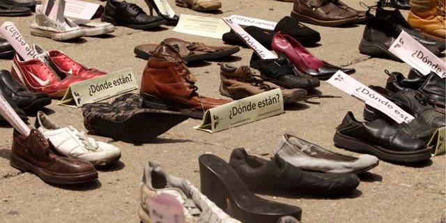 Shoes with signs that read in Spanish: "Where are them?" are displayed right outside the Senate building during a demonstration to protest against violence in Mexico City, Sunday Aug. 14, 2011. The continuing tide of drug-related killings in Mexico has drawn thousands of protesters to march against violence. (AP Photo/Arnulfo Franco)