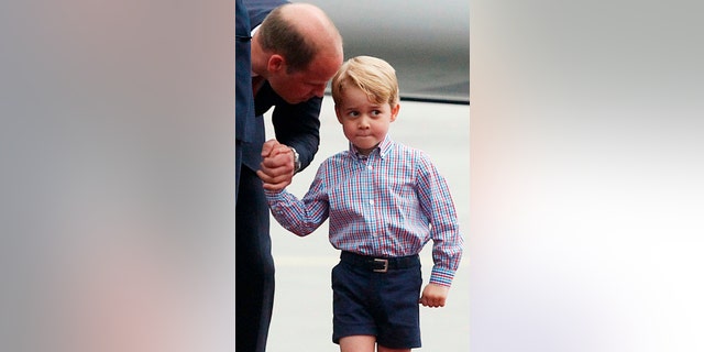 Britain's Prince William, left, holds the hand of his son Prince George.