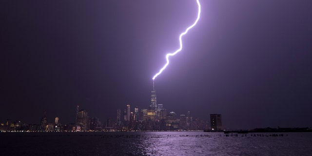 Lightning lights up the sky over Lower Manhattan as a bolt strikes One World Trade Center on August 22, 2017, seen from Hoboken, NJ 