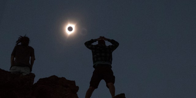 File photo - Enthusiasts Tanner Person (R) and Josh Blink, both from Vacaville, California, watch a total solar eclipse while standing atop Carroll Rim Trail at Painted Hills, a unit of the John Day Fossil Beds National Monument, near Mitchell, Oregon, U.S. August 21, 2017.