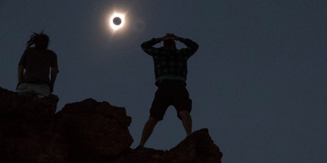 File photo - Enthusiasts Tanner Person (R) and Josh Blink, both from Vacaville, California, watch a total solar eclipse while standing atop Carroll Rim Trail at Painted Hills, a unit of the John Day Fossil Beds National Monument, near Mitchell, Oregon, U.S. August 21, 2017.