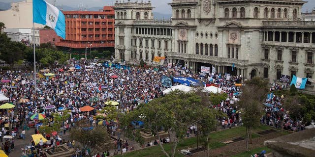 Demonstrators gather outside the National Palace demanding the resignation of Guatemala President Otto Perez Molina, in Guatemala City, Saturday, June 13, 2015. Guatemala's Supreme Court has given the go-ahead for congress to decide whether to remove Perez Molina's immunity from prosecution in a corruption scandal. (AP Photo/Luis Soto)