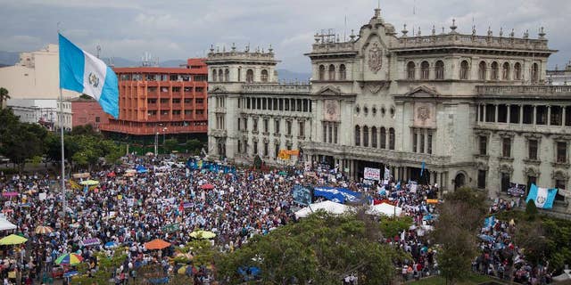 Demonstrators gather outside the National Palace demanding the resignation of Guatemala President Otto Perez Molina, in Guatemala City, Saturday, June 13, 2015. Guatemala's Supreme Court has given the go-ahead for congress to decide whether to remove Perez Molina's immunity from prosecution in a corruption scandal. (AP Photo/Luis Soto)