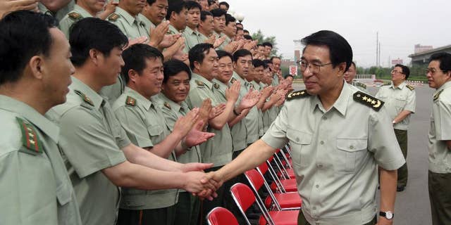 In this July 14, 2004 photo, Xu Caihou, then member of the Secretariat of the Communist Party of China Central Committee and Director-general of General Political Department? of the People's Liberation Army, shakes hands with members of the paramilitary force in Changchun in northeast China's Jilin province. Former No. 2 military official Xu, who was under investigation for alleged massive bribe-taking, has died in a hospital of cancer, the state Xinhua News Agency reported early Monday March 16, 2015. He was 71.(AP Photo) CHINA OUT