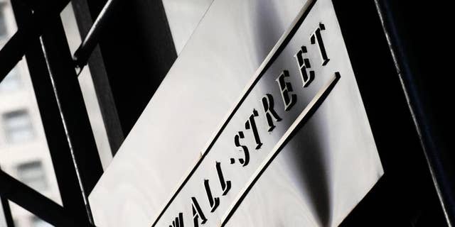 FILE - This July 15, 2013, file photo, shows a sign for Wall Street outside the New York Stock Exchange, in New York. The stock market drifted lower, Wednesday, March 25, 2015, following a drop in durable goods orders and news of a big merger between Kraft and Heinz. (AP Photo/Mark Lennihan, File)