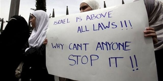 June 1: Jordanian students carry a banner during a rally in support of Turkey, in front of the University of Jordan in Amman, Jordan, after Monday's deadly commando raid by Israeli forces on ships taking humanitarian aid to the blockaded Gaza Strip. Poster reads 'Israel is above all laws, why can't anyone stop it' (AP).