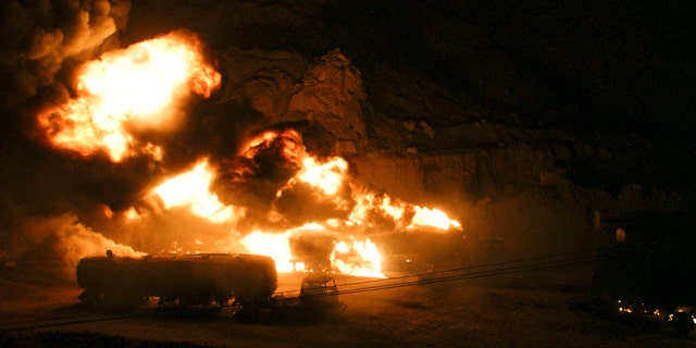 May 31: Afghanistan-bound NATO tankers shoot flames and smoke into the sky after being set on fire.