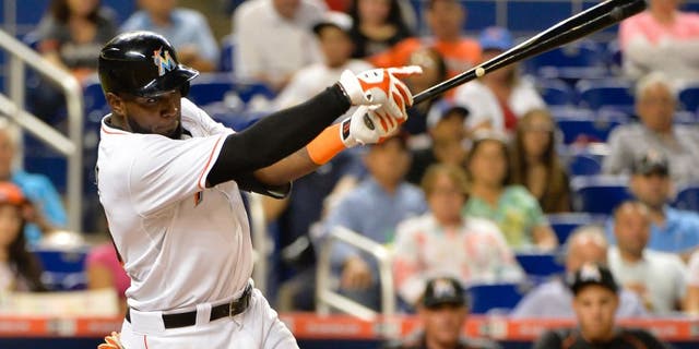 Jun 2, 2015; Miami, FL, USA; Miami Marlins center fielder Marcell Ozuna (13) connects for a base hit during the second inning against the Chicago Cubs at Marlins Park. Mandatory Credit: Steve Mitchell-USA TODAY Sports