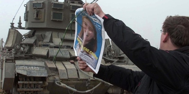 FILE: A member of the International Solidarity Movement waves a picture of pro-Palestinian activist Rachel Corrie in front of an Israeli tank during a demonstration held at the site where Corrie was killed in March 2003.