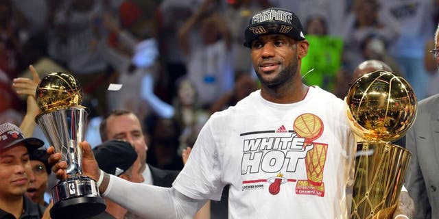 Jun 20, 2013; Miami, FL, USA; Miami Heat small forward LeBron James holds the MVP trophy and the Larry O'Brien Championship trophy after defeating the San Antonio Spurs in game seven in the 2013 NBA Finals at American Airlines Arena. Miami Heat won 95-88 to win the NBA Championship. Mandatory Credit: Steve Mitchell-USA TODAY Sports