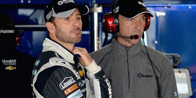 DOVER, DE - MAY 30: Jimmie Johnson, left, driver of the #48 Lowe's/Kobalt Tools Chevrolet, and crew chief Chad Knaus looks on in the garage area during practice for the NASCAR Sprint Cup Series FedEx 400 Benefiting Autism Speaks at Dover International Speedway on May 30, 2014 in Dover, Delaware. (Photo by Patrick Smith/Getty Images)