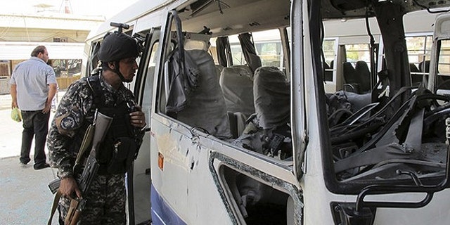 May 15: A policeman inspects a damaged bus after a rocket landed in central Baghdad. One person was killed and nine others wounded when nine Katyusha rockets landed in Baghdad's fortified Green Zone, where the U.S. embassy and Iraqi government officials' houses are located, and other central and southern areas of the Iraqi capital, the Baghdad security operations centre said.