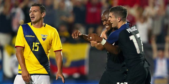 FRISCO, TX - MAY 25: Pedro Larrea #15 of Ecuador reacts as Darlington Nagbe #10 of the United States celebrates with Christian Pulisic #17 of the United States after scoring against Ecuador during an International Friendly match at Toyota Stadium on May 25, 2016 in Frisco, Texas. (Photo by Tom Pennington/Getty Images)