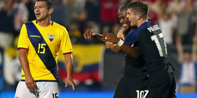 FRISCO, TX - MAY 25: Pedro Larrea #15 of Ecuador reacts as Darlington Nagbe #10 of the United States celebrates with Christian Pulisic #17 of the United States after scoring against Ecuador during an International Friendly match at Toyota Stadium on May 25, 2016 in Frisco, Texas. (Photo by Tom Pennington/Getty Images)