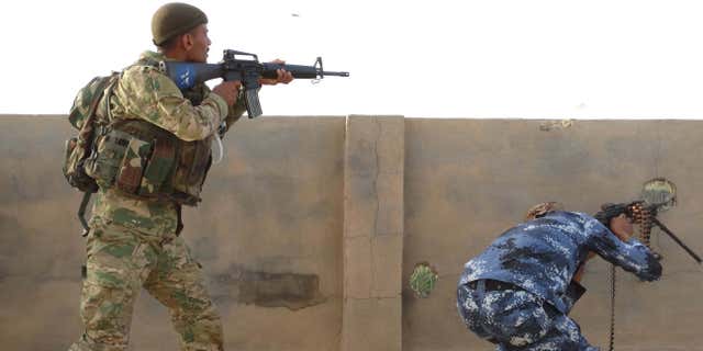 June 4, 2015: Iraqi Federal Police and Shiite Hezbollah Brigade militiamen fight against the Islamic State group as they defend their positions on the front line in eastern Husaybah, 5 miles east of Ramadi, Iraq.