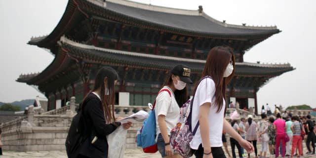 June 7, 2015: Tourists wear masks as a precaution against MERS, Middle East Respiratory Syndrome, virus as they visit Gyeongbok Palace, one of South Korea's well-known landmarks, in Seoul, South Korea.