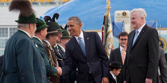 June 7, 2015: US President Barack Obama, joined by Horst Seehofer, Minister President of Bavaria, right, is greeted by traditionally dressed Bavarian men and women as he arrives on Air Force One at the airport in Munich, southern Germany.