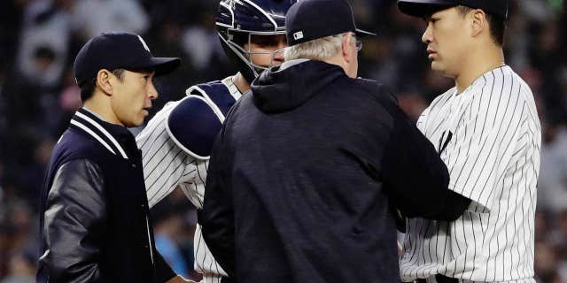 June 6, 2017: New York Yankees starting pitcher Masahiro Tanaka, of Japan, right, talks to catcher Gary Sanchez, second from left, pitching coach Larry Rothschild and translator Shingo Horie, left, during the fourth inning of a baseball game in New York.